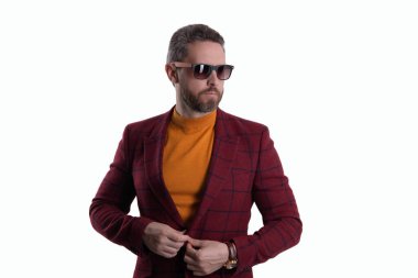 Beyaz tenli şık bir adam. Yakışıklı İspanyol adam modayı takip ediyor. Erkekler için moda. Ceket ve güneş gözlüğü takan kendinden emin bir iş adamı. Erkek modası. Terzi karmaşıklığı.