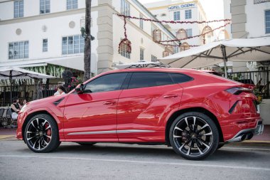 Miami, Florida, ABD - 02 Aralık 2024 Lamborghini Urus lüks SUV kırmızı araba. Lüks arazi aracı Lamborghini Urus. Araba siyah Lamborghini Urus dışarı park etmiş. Lamborghini Urus, köşe manzaralı..