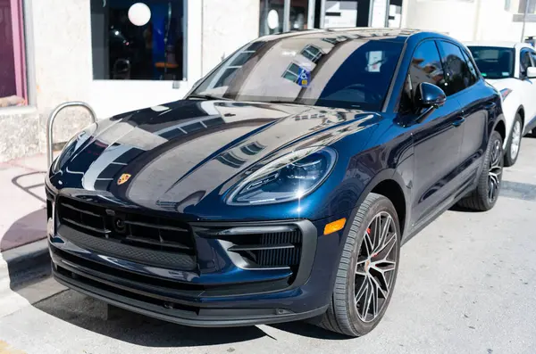 Miami, Florida, ABD - 21 Aralık 2024: Porsche Macan 2020 geçişi koyu mavi araba. Lüks araba Porsche Macan. Araba siyah renkli Porsche Macan dışarıda park etmiş. Porsche Macan, köşe görünümü.