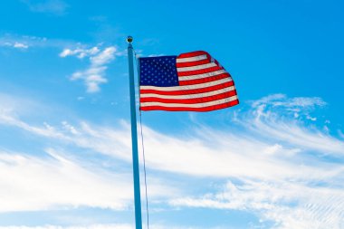 Amerikan bayrağı bağımsızlık günü için dalgalanıyor. ABD bayrağı. Mavi gökyüzünde Birleşik Devletler bayrağı sallıyor. Bağımsızlık Günü. Vatanseverlik sembolü. Anma Günü veya 4 Temmuz 'da Amerikan Bayrağı.