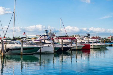 Limanda kiralık bir yat. Yat marinası. Lüks yat kiralama. Miami limanı marinası. Yazın lüks bir yat gezisi. Miami plajına demir atmış bir yat. Marina lüks şehir manzarası. Lüks yaşam tarzı..