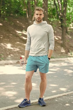 Adam maden suyu tutuyor. Susadım. Plastik şişeli genç bir adam. Sağlıklı bir yaşam tarzı. Vücuttaki su dengesini korumak. Günde bir içki. Sıvı yeterliliği. Susuz kalma. Susamış sporcu..