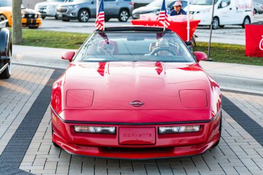Park Ridge, Illinois, ABD - 22 Ağustos 2024: Sokakta önü görünen insanların olduğu üstü açık bir araba. Chevrolet Corvette C4 eski araba. Chevrolet Corvette C4 'ün üstü açık arabası. Chevy Corvette.