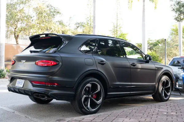 Miami, Florida, ABD - 05 Aralık 2024 Bentley Bentayga SUV siyah mat araba. Lüks SUV Bentley Bentayga. Bentley Bentayga 'nın açık havada park ettiği siyah araba. Bentley Bentayga, yan görüş..