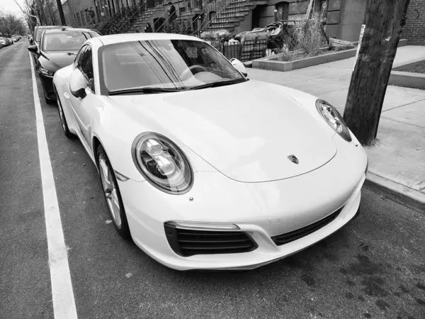 New York, ABD - 10 Şubat 2024: Porsche 911 beyaz araba parkı, köşe manzaralı.