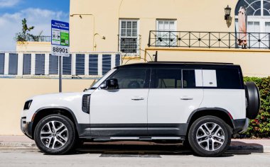 Miami, Florida, ABD - 17 Aralık 2024: 2025 Land Rover Defender SUV beyaz araba. Lüks arazi aracı Land Rover Defender. Açık havada park edilmiş beyaz Land Rover Defender arabası. Land Rover Defender, köşe görünümü.