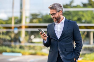 Takım elbiseli adam telefonu sohbeti. Telefonu olan olgun bir İspanyol iş adamı. İş iletişimi. Mesajlaşma ve mesajlaşma. İş adamı dışarıda telefonla konuşuyor. Telefon kullanan bir iş adamı. Boşluğu kopyala.