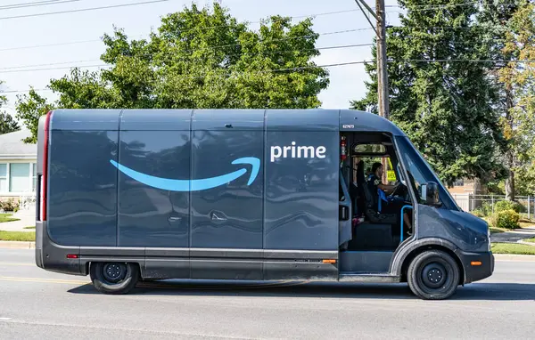 Park Ridge, Illinois, ABD - 29 Ağustos 2024: Rivian EDV Elektrik Teslimat Minibüsü. Rivian EDV 'nin lüks elektrikli minibüsü. Rivian minibüsü yolda. Rivian EDV dağıtım aracı, yan görünüm.