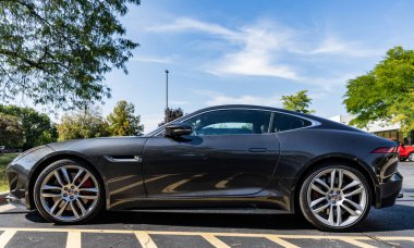 Park Ridge, Illinois, ABD - 29 Ağustos 2024: 2016 Jaguar F spor arabası. Jaguar F tipi lüks bir spor araba. Jaguar F spor arabası dışarıda park edilmiş. Jaguar F, yan görünüm.