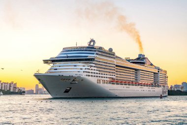 Miami, Florida, ABD - 21 Aralık 2024: MSC Divina yolcu gemisi yolculuğu. Yaz tatilinde gemi turu. MSC yolcu gemisinde. Gemi turu ve deniz seyahati. Gemi gün batımında limandan ayrılıyor..