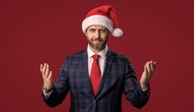 Noel Baba şapkalı mutlu iş adamı kırmızıda izole edilmiş. Noel Baba iş adamının stüdyo fotoğrafı. Noel işadamı Noel Baba şapkası takar. İş adamı Noel Baba şapkası takıyor. Mutlu Noeller..