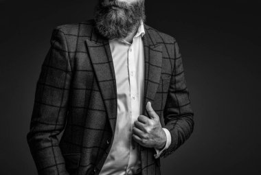 Zarif takım elbiseli hırslı bir adam. Erkekler için resmi moda. Erkek giyim modeli. Takım elbiseli şık bir adam. Sakallı bir iş adamı. Gri yolda yabani sakallı adam. Kırpılmış görünüm.