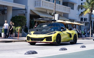 Miami, Florida, ABD - 23 Kasım 2024 Chevrolet Corvette Stingray sarı spor yara izi. Lüks araba Chevy Corvette. Araba sarı, siyah Chevy Corvette açık havada. Chevrolet Corvette, köşe manzaralı..