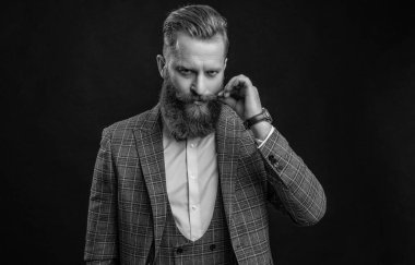 Resmi smokinli şık sakallı adam siyah giyinmiş..