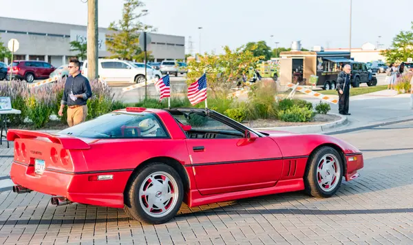 Park Ridge, Illinois, ABD - 22 Ağustos 2024: Sokakta önü görünen insanların olduğu üstü açık bir araba. Chevrolet Corvette C4 eski araba. Chevrolet Corvette C4 'ün üstü açık arabası. Chevy Corvette.