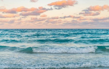 Deniz doğarken sakin ufuk manzarası. Deniz manzarasında romantik yaz tatili gündoğumu. Deniz ufku manzarası. Yaz tatilinde bulutlu gökyüzü ve deniz manzarası. Deniz ufkuyla gökyüzü. Ufukta gün batımı.