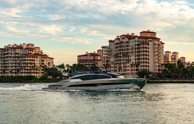 Marinaya yüzen bir tekne. Fisher Adası 'nda lüks bir yat teknesi. Yaz tatili. Fisher Adası konut binası ve lüks yat teknesi. Miami 'de Fisher Adası' na yat gezisi..