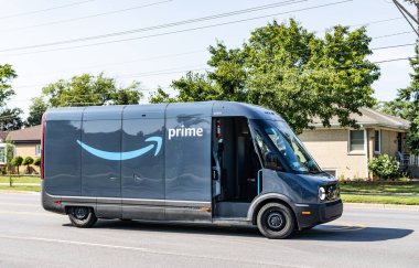 Park Ridge, Illinois, ABD - 29 Ağustos 2024: Rivian EDV Elektrik Teslimat Minibüsü. Rivian EDV 'nin lüks elektrikli minibüsü. Rivian minibüsü yolda. Rivian EDV dağıtım aracı, yan görünüm.
