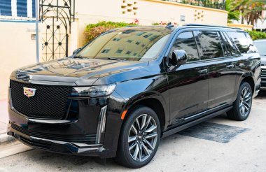 Miami, Florida, ABD - 4 Nisan 2025: lüks spor araba Cadillac Escalade ESV. Araba Cadillac Escalade ESV dışarıda park halinde. Siyah spor araba, köşe manzaralı. 2023 Cadillac Escalade ESV Spor Araba.