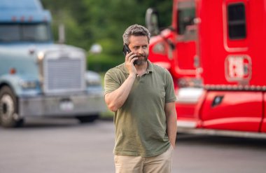 Yarı kamyon aracı. İspanyol kamyoncu adam. Mobil iletişim. Kamyon şoförü telefonda konuşuyor. Kamyon sahibi. Kamyon şoförüne telefon var. Kamyon şoförlüğü yapan adam. Sabit iletişim.