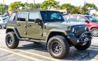 Park Ridge, Illinois, ABD - 29 Ağustos 2024: Jeep Wrangler 2015 SUV arabası. Jeep Wrangler SUV tipi lüks bir araba. Jeep Wrangler 'ın arabası dışarıda park yerinde. Jeep Wrangler, yan görüş..