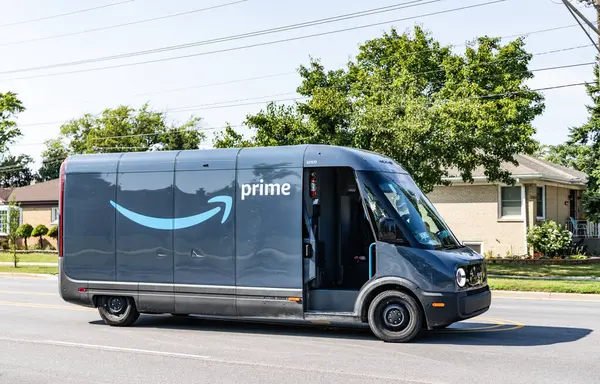 Park Ridge, Illinois, ABD - 29 Ağustos 2024: Rivian EDV Elektrik Teslimat Minibüsü. Rivian EDV 'nin lüks elektrikli minibüsü. Rivian minibüsü yolda. Rivian EDV dağıtım aracı, yan görünüm.