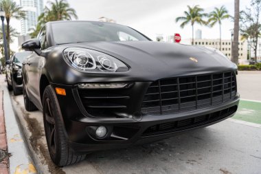 Miami, Florida, ABD - 02 Nisan 2025: siyah mat araba, köşe manzaralı. Porsche Macan 2015 çapraz arabası. Lüks araba Porsche Macan. Porsche Macan 'ın arabası dışarıda park edilmiş..