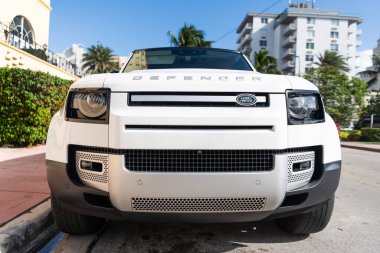 Miami, Florida, ABD - 17 Aralık 2024: 2025 Land Rover Defender SUV beyaz araba. Lüks arazi aracı Land Rover Defender. Açık havada park edilmiş beyaz Land Rover Defender arabası. Land Rover Defender, ön görünüm.