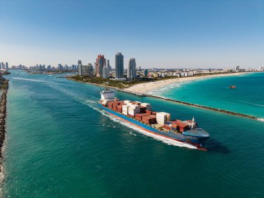 Denize bakan kargo gemisi. Kargo işi. Konteyner gemisi. Nakliye lojistiği. Ticari nakliye. Kargo gemisi denizde, hava manzaralı. Yük konteynırı kargo gemisine yüklendi.