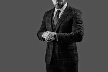 Takım elbiseli dakik bir işadamı iş saatlerini kontrol ediyor..