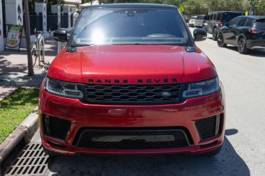 Miami, Florida, ABD - Nisan 06, 2025: 2019 Land Rover Range Sport HSE arabası. Lüks arazi aracı Range Rover. Otomobil Range Rover 'ı dışarıda park etmiş. Kırmızı SUV arabası, ön manzara..