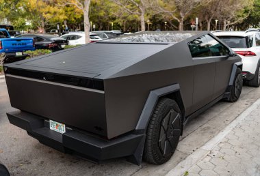 Miami, Florida, ABD - 06 Nisan 2025: Tesla Cybertruck otomobili açık hava parkı. Matte elektrikli araba, yan görüş. 2024 Tesla Cybertruck elektrikli kamyonet vagonu. Elektrikli kamyonet vagonu Tesla Cybertruck.