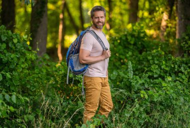 Seyahat yaşam tarzı. Kırsalda yürüyüş yapan bir adam. İspanyol adam ormanı. Ormanda yürüyüş yapan sırt çantalı bir yürüyüşçü. Erkek yürüyüşçü ormanda yürüyor. Sırt çantalı bir gezgin. Yürüyüş macerası. Orman yürüyüşü.