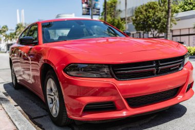 Miami, Florida, ABD - 01 Nisan 2025: Dodge Charger SXT açık havada park edilmiş. Kırmızı spor araba, köşe manzaralı. 2022 Dodge Charger SXT modern spor sedan araba. Lüks spor araba Dodge Charger SXT.