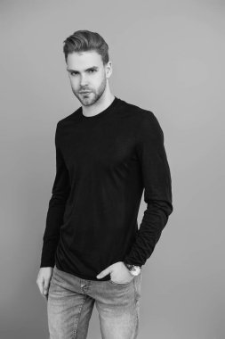 Erkeklerin güzelliği. Kendine güveni olan adam. Gündelik kazak giyen genç yakışıklı bir adam. Tıraşsız adam Griler 'de izole edilmiş. Şık saç kesimi olan bir adamın portresi. Milenyum karizmatik modeli. Duygusal Manyetizma.