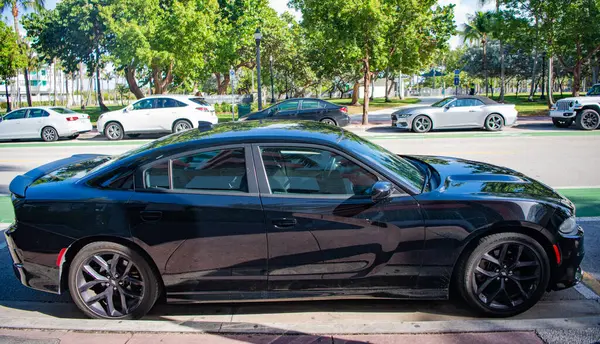 Miami, Florida, ABD - 17 Aralık 2024: Siyah 2023 Dodge Charger GT arabası. Dodge Charger GT tipi lüks bir araba. Dodge Charger GT 'nin arabası, dışarıda park edilmiş. Dodge Charger GT, yan görünüm.