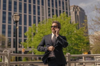 İş adamının dışarıyı araması gerekiyor. Telefon kullanan bir iş adamı. Takım elbiseli bir adam telefonda konuşuyor. Telefonu olan orta yaşlı İspanyol işadamı. İş iletişimi. Ortak iletişim..