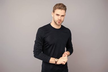 Kendine güvenen adam portresi. Erkeklerin cilt bakımı. Erkek derisi. Adamın şık bir saç kesimi var. Moda saç stili olan bir adam. Sıradan erkek tarzı. Beyazlı genç bir adam gri yolda izole edilmiş. Etkileyici Gözler.