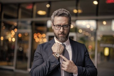 Zaman yönetimi. Dakik adam nöbette parmağıyla işaret ediyor. Nöbetçi bir iş adamı. Dakik iş adamı dışarıda zamanı kontrol ediyor. İş için son gün. İşadamı son teslim tarihine geç kaldı.