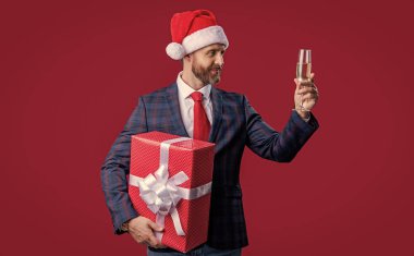 Noel Baba şapkalı pozitif Xmas işadamı. İş adamı bayramı kutluyor. Noel 'i kutlayalım. İşadamı kırmızıda izole edilmiş Xmas 'ı kutluyor. Şimdiki işadamı kutlama yapıyor..