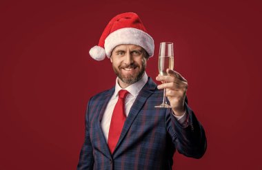 Noel 'i kutluyoruz. Kırmızıda izole edilmiş Xmas 'ı kutlayan iş adamı. Xmas işadamı kutluyor. Noel Baba şapkalı xmas işadamı. İş adamı bayramı kutluyor.