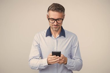 İş adamı sohbeti. İş adamı mesajlaşması ve mesajı. Sosyal ağ. Telefonu olan olgun bir iş adamı. Telefon kullanan bir iş adamı. Gri yolda insan telefonu görüşmesi izole edildi. Sohbet desteği.