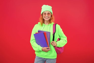 Modern eğitim. Kız öğrenci çalışma kitabını tutuyor. Okula dönelim. Bilgi toplama günü. Üniversitede eğitim. Pembe üzerine izole edilmiş bir kızın ödevi. Bilgi ve eğitim. Okul eğitimi. Bilgi ediniliyor.