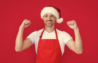 Kırmızı barmen önlüklü ve Noel Baba şapkalı başarılı bir olgun adam..