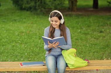 Eğitim ve bilgi. Kızım sesli kitap dinle ve kitap oku. Audiobook kitaba karşı. Öğrenci kız. Okul eğitimi. Liseli kız dışarıda kitap okur ve sesli kitap dinler. Okula geri dön..