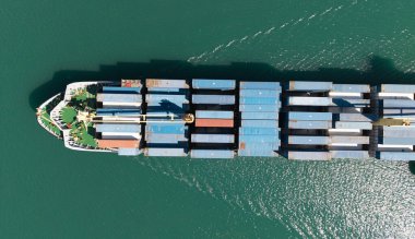 Konteynırlı kargo gemisi, hava manzaralı. Kargo gemisinde nakliye konteynırı. Kargo gemisi limandan ayrılıyor. Konteyner gemisi. İhraç ve ithalat. Kargo işi. Nakliye lojistiği.