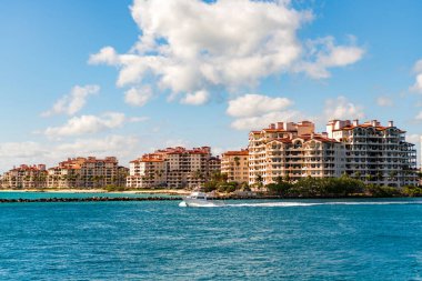Marinaya yüzen bir tekne. Fisher Adası 'nda lüks bir yat teknesi. Yaz tatili. Fisher Adası konut binası ve lüks yat teknesi. Miami Fisher Adası Panorama Manzarası.