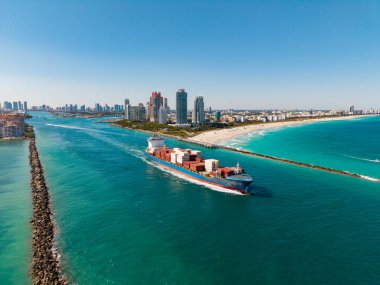Yük konteynırı kargo gemisine yüklendi. Limandan ayrılan hava görüntülü kargo gemisi. Kargo işi. Konteyner gemisi. Nakliye lojistiği. Ticari nakliye. Kargo gemisi denizde, hava manzaralı..