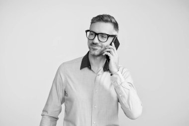 Telefon kullanan bir iş adamı. Gözlüklü bir adam telefonda konuşuyor. Telefonu olan olgun bir iş adamı. İş iletişimi. İş adamı Grey 'de telefon görüşmesi yapıyor..