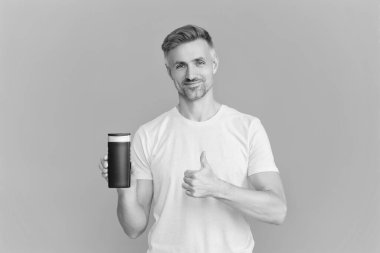 Adam şampuan kullanıyor. Olgun adam saç kremi kullanır. Tıraş losyonlu adam. Günlük alışkanlık ve kişisel bakım. Cilt güzellik kozmetiği. Şampuan ya da tıraş losyonu. Erkek kozmetik ürününü sunuyorum. Başparmak yukarı..